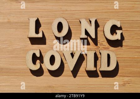 Long Covid, mots en lettres de l'alphabet en bois isolés sur fond de bois Banque D'Images