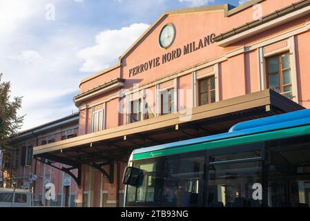 Transports publics dans le nord de l'Italie. Chemins de fer Nord Milano, comme écrit, à la gare Saronno sur la ligne Laveno - Milan avec un bus attendant à l'extérieur Banque D'Images