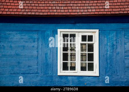 Vieille fenêtre en bois dans un bâtiment en rondins peint en bleu ; Sisimiut, Groenland Banque D'Images