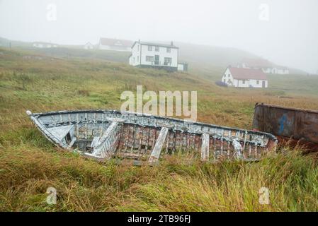 Bateau de pêche délabré est assis haut et sec dans l'herbe ; Battle Harbour, Terre-Neuve-et-Labrador, Canada Banque D'Images