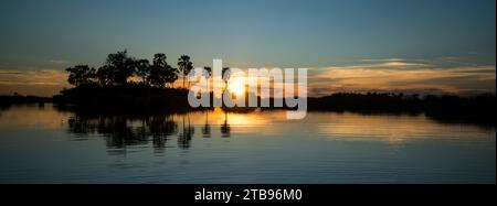 Coucher de soleil sur un plan d'eau à la réserve de Selinda ; réserve de Selinda, Botswana Banque D'Images