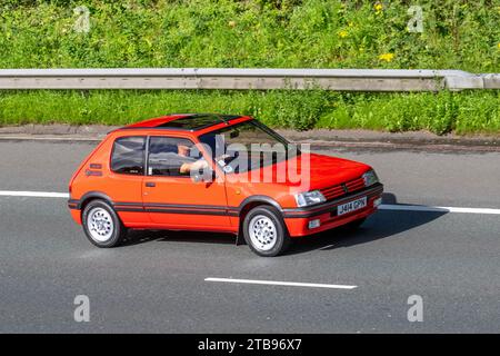 Années 1992 90 années 1990 Rouge PEUGEOT 205 3 portes supermini, GL 1,6 1580cc GTI ; voyageant à grande vitesse sur l'autoroute M6 dans le Grand Manchester, Royaume-Uni Banque D'Images