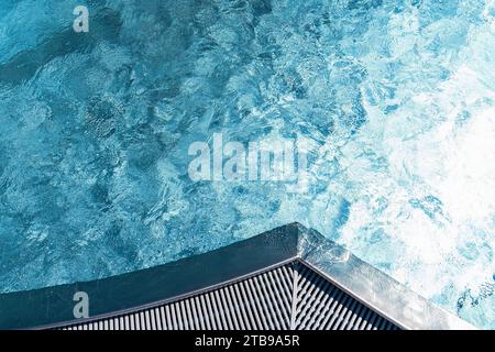 Vue du dessus du coin de la piscine avec eau bleue texturée et bord de caillebotis Banque D'Images