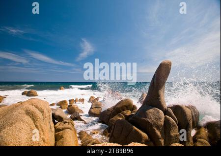 Eau bleue éclaboussant contre les rochers sur la plage de la Côte d'Azur ; Côte d'Azur, France Banque D'Images