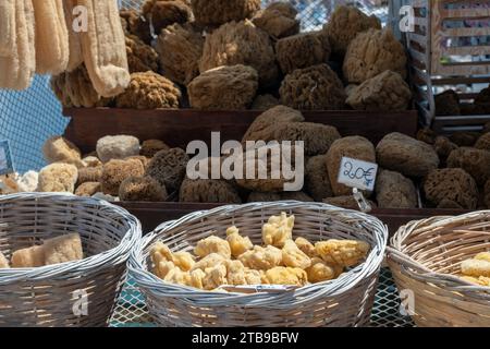 Éponge de mer naturelle à vendre avec étiquette de prix au banc de magasin extérieur en Grèce. Pile d'éponge organique sèche entière ou en morceaux. Bain, spa, soins de santé. Banque D'Images