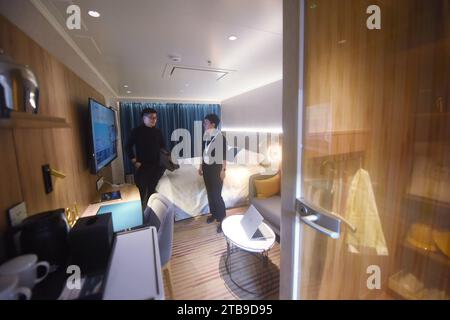 Shanghai, Chine. 05 décembre 2023. Les visiteurs regardent la cabine avec vue sur la mer d'Aida Modu, le premier grand navire de croisière construit localement, à bord du Marintec China 2023 à Shanghai, en Chine, le 5 décembre 2023. (Photo Costfoto/NurPhoto) crédit : NurPhoto SRL/Alamy Live News Banque D'Images