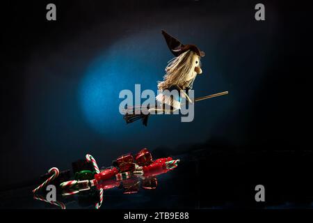 Tradition italienne du jour de l'Epiphanie. Sorcière Befana volant sur balai, lumière de lune, bonbons de Noël et charbon doux Banque D'Images