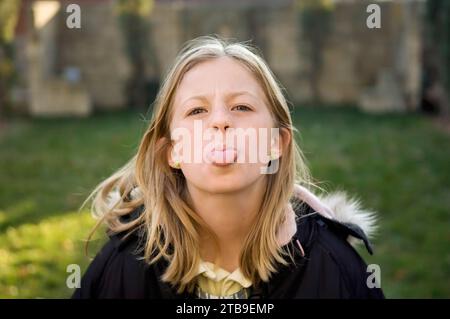 Une fille de 10 ans tire la langue devant la caméra ; Lincoln, Nebraska, États-Unis d'Amérique Banque D'Images