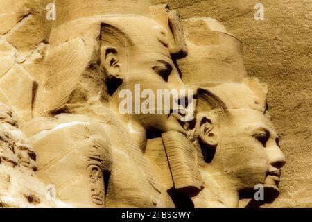 Gros plan de deux des statues de Ramsès II sculptées à flanc de montagne à l'avant du Temple du Grand Soleil d'Abou Simbel ; Abou Simbel, Nubie, Égypte Banque D'Images