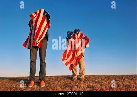 Deux personnes se couvrent de drapeaux américains ; Lincoln, Nebraska, États-Unis d'Amérique Banque D'Images