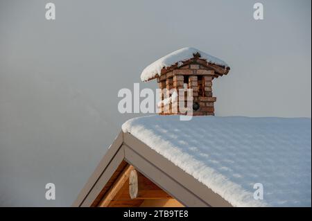 Pot de cheminée sur un toit couvert de neige Banque D'Images