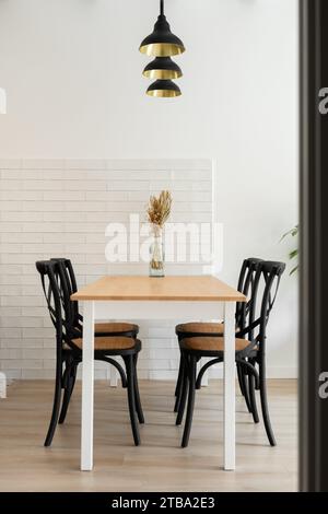 Bouquet de fleurs séchées sur la table à manger sous le lustre Banque D'Images