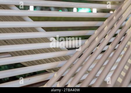 Photo de closeup de nuit de banc de parc de structure de tube blanc dans un environnement urbain de ville. Banque D'Images