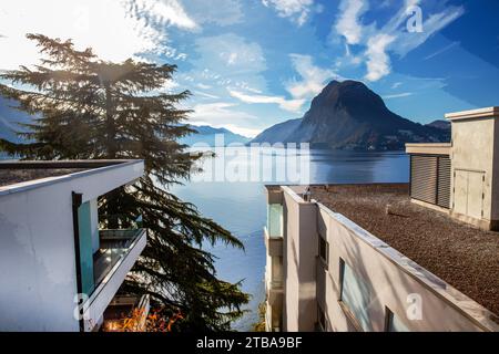 Panorama incroyable sur le lac de Lugano avec une partie de bâtiment moderne sur des shote et des sapins émerveillés. Vue depuis Olive Trail dans la banlieue de la ville de Lugano Banque D'Images