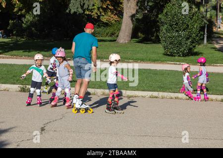 Instructeur de patinage roulant pour les enfants dans le parc, Parque Del Buen Retiro, Madrid, Espagne Banque D'Images