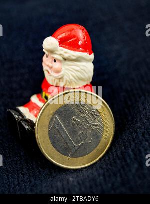 Père Noël avec pièce en euro, symbole image pour bonus de fin d'année Banque D'Images