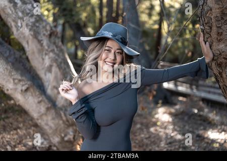 Jeune Fit Curvy asiatique Femme penchée sur l'arbre en costume de sorcière forestière | académie de magie beauxbatons Banque D'Images