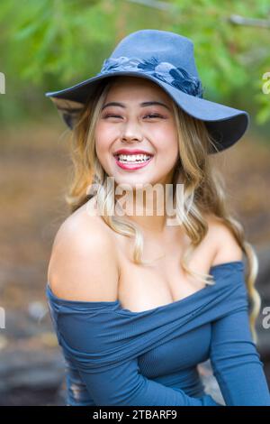 Gros plan Beautiful Fit Curvy Femme asiatique en costume de sorcière riant assis | beauxbatons academy of Magic Banque D'Images