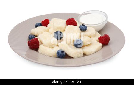 Assiette de délicieuses boulettes paresseuses avec des baies et de la crème sure isolée sur blanc Banque D'Images