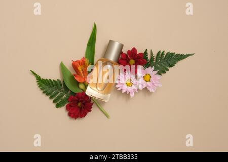 Scène publicitaire de produits parfumés extraits d'huiles essentielles naturelles de fleurs et de feuilles. Maquette bouteille en verre avec de belles fleurs et fougère leave Banque D'Images