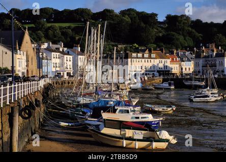 St Aubin : Yachts et bateaux amarrés dans le port peu après le lever du soleil, avec église à St Aubin, îles Anglo-Normandes, Royaume-Uni Banque D'Images