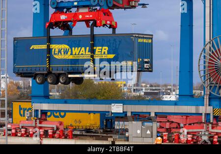 Rostock, Allemagne. 21 novembre 2023. Une remorque de la société logistique LKW Walter est chargée dans un train au port maritime avec d'autres remorques. Plusieurs centres logistiques opèrent dans le port maritime de Rostock et manipulent des marchandises. Crédit : Jens Büttner/dpa/Alamy Live News Banque D'Images