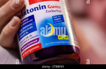 Leipzig, Allemagne. 05 décembre 2023. ILLUSTRATION - Un enfant tient un paquet d'ours gommeux contenant de la mélatonine. Ces compléments alimentaires sont censés aider les enfants à s’endormir plus rapidement. (À dpa 'tendance dangereuse : les pédiatres mettent en garde contre la mélatonine comme aide au sommeil') crédit : Jan Woitas/dpa/Alamy Live News Banque D'Images