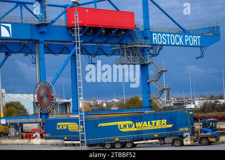 Rostock, Allemagne. 21 novembre 2023. Une remorque de la société logistique LKW Walter est chargée dans un train au port maritime avec d'autres remorques. Plusieurs centres logistiques opèrent dans le port maritime de Rostock et manipulent des marchandises. Crédit : Jens Büttner/dpa/Alamy Live News Banque D'Images