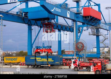 Rostock, Allemagne. 21 novembre 2023. Une remorque de la société logistique LKW Walter est chargée dans un train au port maritime avec d'autres remorques. Plusieurs centres logistiques opèrent dans le port maritime de Rostock et manipulent des marchandises. Crédit : Jens Büttner/dpa/Alamy Live News Banque D'Images