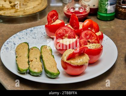 Concombres farcis et tomates prêts à cuire sur plaque. Banque D'Images