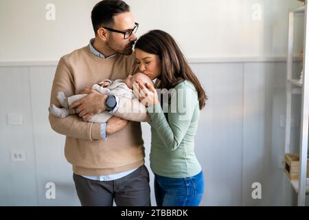 Concept de famille, d'adoption, de bébé, de parentalité et de personnes. Mère heureuse père avec bébé nouveau-né à la maison Banque D'Images