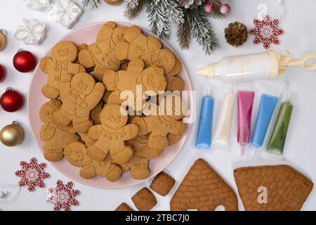 Pain d'épice de Noël en forme d'hommes et un ensemble de glaçage au sucre coloré pour la décoration Banque D'Images