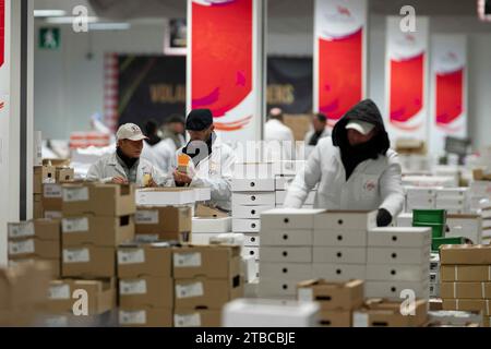 Cette photographie montre un employé qui travaille au pavillon volatile du marché International de Rungis, banlieue sud de Paris, le 6 décembre 2023. Le marché International de Rungis (Marche International de Rungis) est le principal marché de Paris, principalement pour les produits alimentaires et horticoles, situé sur la commune de Rungis, dans la banlieue sud. C'est le deuxième plus grand marché alimentaire en gros dans le monde après Central de Abasto, situé dans la ville de Mexico. Depuis ses origines au 10e siècle jusqu’au milieu du 20e siècle, le marché central de Paris était situé au centre de la ville, dans un 10-hec Banque D'Images