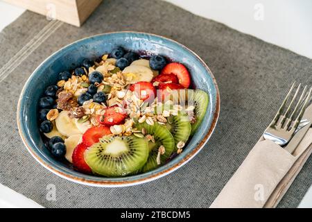 un bol de crème glacée d'açai garni de fruits fraîchement tranchés et d'avoine dans un restaurant Banque D'Images