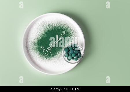 Plaque en céramique blanche avec Word Spirulina faite de poudre d'algues vertes naturelles. Bol en verre avec comprimés ronds bio. Detox Banque D'Images