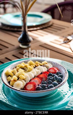 une image portrait en gros plan d'un bol de crème glacée d'açai tropical surmonté de fruits frais. Banque D'Images