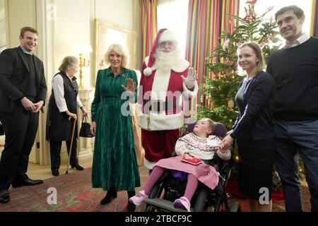 La reine Camilla, accompagnée d'enfants soutenus par Helen and Douglas House et la Marvellous Children's Charity de Roald Dahl, décorent le sapin de Noël de Clarence House à Londres. Date de la photo : mercredi 6 décembre 2023. Banque D'Images