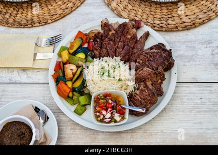 une vue sur une assiette de viande grillée servie avec riz et légumes mélangés dans un restaurant. Banque D'Images