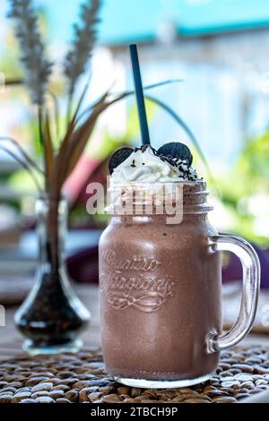 une image rapprochée d'un milk-shake au chocolat fraîchement préparé garni de biscuits et de crème Banque D'Images