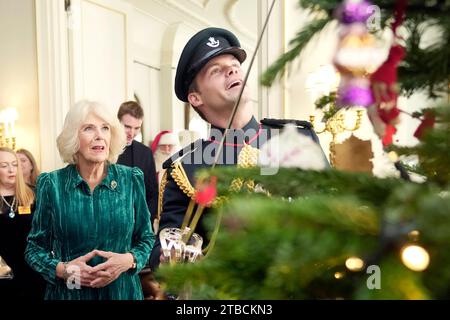 La reine Camilla, accompagnée d'enfants soutenus par Helen and Douglas House et la Marvellous Children's Charity de Roald Dahl, décorent le sapin de Noël de Clarence House à Londres. Date de la photo : mercredi 6 décembre 2023. Banque D'Images