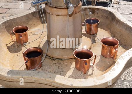 Natla en cuivre ou tasses rituelles juives à laver les mains se trouvent dans un évier en marbre près du mur occidental à Jérusalem. Banque D'Images