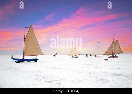 Voile sur glace sur le Gouwzee en hiver aux pays-Bas au coucher du soleil Banque D'Images