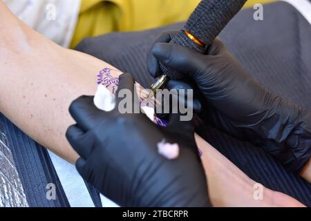 Tatoueur créant tatouage sur la main. Concept d'art et de design. Gros plan Banque D'Images