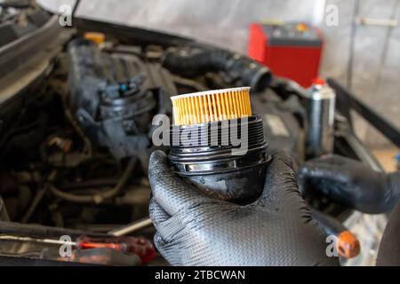 Remplacement du filtre à huile de voiture. Homme mécanicien tenant le filtre à huile de moteur de voiture dans sa main Banque D'Images