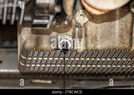 Remplacement de l'huile moteur usagée dans le service de réparation automobile. entretien et contrôle dans l'atelier automobile. Auto est sur l'ascenseur hydraulique dans l'atelier de garage Banque D'Images