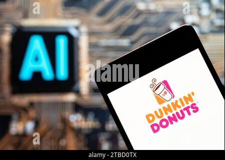 Dans cette illustration photo, le logo de la chaîne multinationale américaine de café et snack Dunkin' Donuts est affiché sur un smartphone avec une puce d'intelligence artificielle (IA) et un symbole en arrière-plan. Banque D'Images