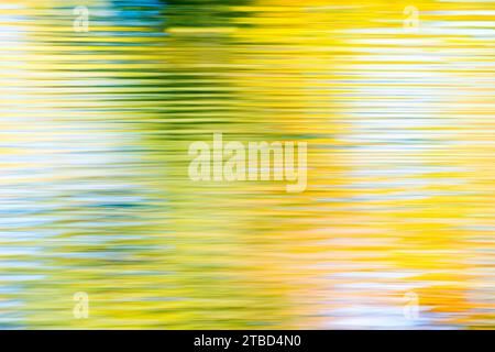 Les feuilles d'automne colorées et le ciel bleu se reflètent dans l'eau des étangs de Bockelsberg, les petites vagues forment des lignes, effet d'essuyage, abstrait, Lueneburg Banque D'Images