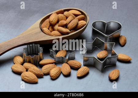 Louche en bois avec amandes et emporte-pièces, ingrédient de boulangerie Banque D'Images