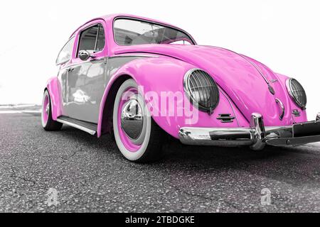 Volkswagen Beetle 1966. Vieille voiture restaurée rose personnalisée garée dans la rue. Mise au point sélective. Banque D'Images