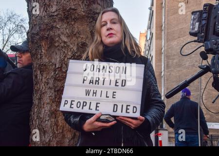 Londres, Angleterre, Royaume-Uni. 6 décembre 2023. Un manifestant se tient devant le Centre d’enquête Covid-19 alors que l’ancien Premier ministre Boris Johnson arrive pour une audience. (Image de crédit : © Vuk Valcic/ZUMA Press Wire) USAGE ÉDITORIAL SEULEMENT! Non destiné à UN USAGE commercial ! Banque D'Images